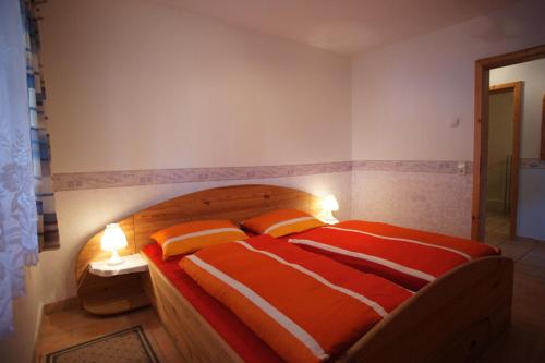 a bedroom with a bed with two orange and white pillows at Fehmarn-OstseeferienFewoAnders11591 in Neue Tiefe Fehmarn