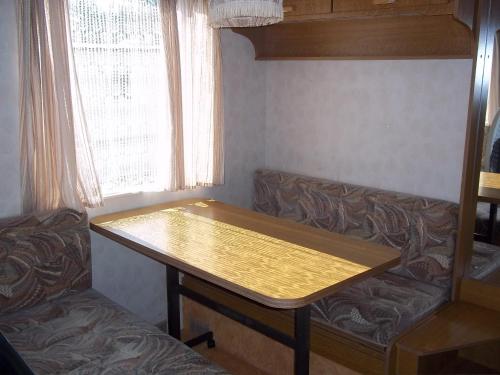 a wooden table in a room with a couch at Višķezers in Višķi