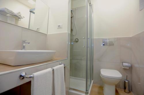 a bathroom with a sink and a toilet and a shower at Path House - Etna & Sea View in Riposto