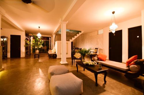 a living room with a couch and a table at TROPICAL HOUSE - Jungleside Villa in Hikkaduwa