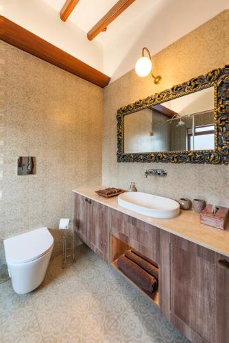 a bathroom with a sink and a mirror at Saffronstays Casa Del Palms, Alibaug - luxury pool villa with chic interiors, alfresco dining and island bar in Alibaug