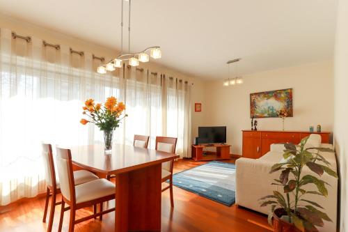 a living room with a dining room table and a couch at Sweet Living Viana - City Centre Apartment with Garage in Viana do Castelo