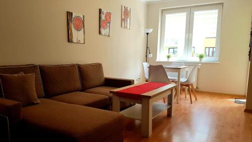a living room with a couch and a table at Apartament Karolina - Zielone Tarasy in Kołobrzeg