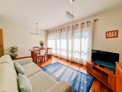 a living room with a couch and a tv and a table at Sweet Living Viana - City Centre Apartment with Garage in Viana do Castelo