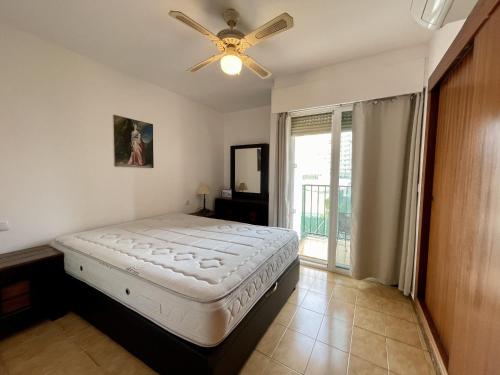 1 dormitorio con 1 cama y ventilador de techo en Rinconada Real Levante Beach, en Benidorm