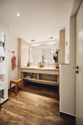 Un baño con lavabo y un espejo grande. en Hotel Haus am Meer, en Norderney