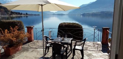 een tafel en stoelen op een balkon met uitzicht op een meer bij My Holidays - La Terrazza sul Lago in Gravedona