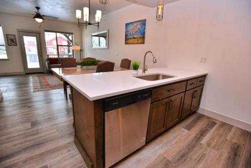 a kitchen with a sink and a living room at The Highland Hangout by Casago McCall - Donerightmanagement in McCall