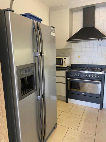 a kitchen with a stainless steel refrigerator and a stove at Oostduinkerke Apartments in Oostduinkerke