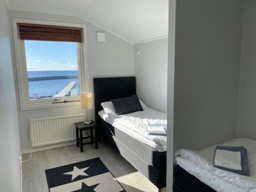 Habitación pequeña con 2 camas y ventana en Byxelkroks Marina Sea Resort, en Byxelkrok