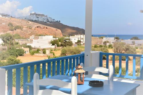 uma mesa e cadeiras numa varanda com vista para o oceano em Drouga's Studios & Suites Astypalaia Greece em Livadi Astypalaias