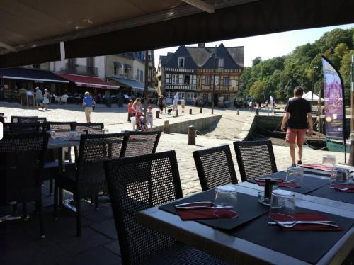 a couple of tables and chairs with people walking on a street at Coup de Coeur sur le Port de ST GOUSTAN, Trés Bel Appartement avec Terrasse in Auray