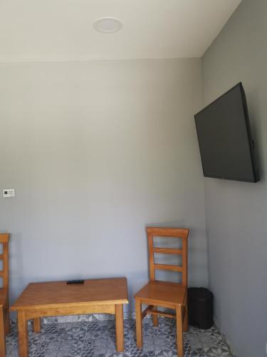 a room with two chairs and a table and a tv at Podlovics Tanya Panzió in Kemecse