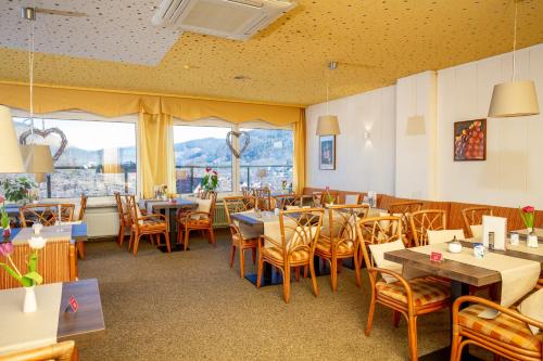a restaurant with tables and chairs and a large window at Hotel Heikenberg in Bad Lauterberg