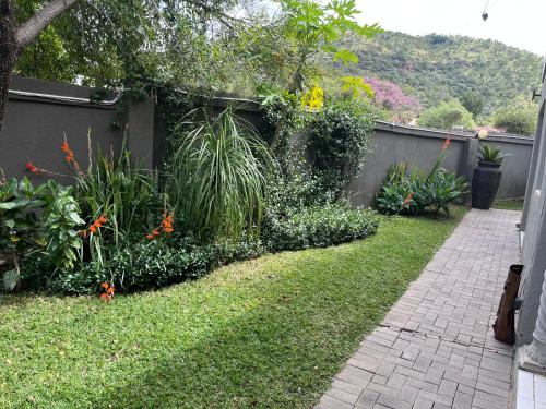 ラステンバーグにあるToro Guest Houseの草木の庭、柵、歩道
