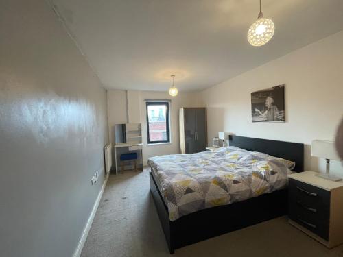 a bedroom with a bed and a desk in it at Modern Apartment near Bullring in Birmingham