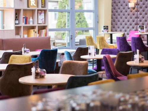 a row of tables and chairs in a restaurant at Mercure Residenz Frankfurt Messe in Frankfurt/Main