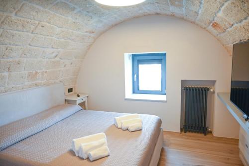 a bedroom with a bed with two towels on it at La casa di Alice in Monopoli