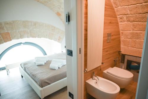 a bathroom with a bed and a sink and a toilet at La casa di Alice in Monopoli