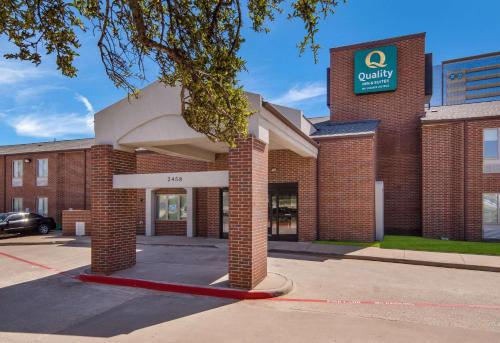 a building with a sign on the front of it at Quality Inn & Suites Richardson-Dallas in Richardson