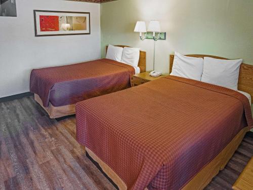 a room with two beds in a hotel room at Rodeway Inn Albuquerque Downtown on Rt 66 in Albuquerque