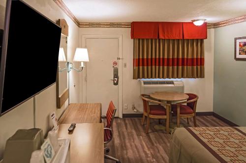 a small hotel room with a table and a room at Rodeway Inn Albuquerque Downtown on Rt 66 in Albuquerque