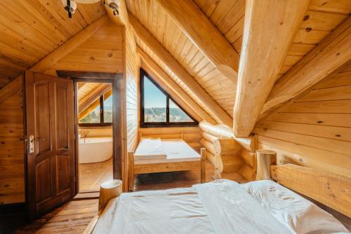 una camera da letto in una baita di tronchi con letto e vasca di Prosilva House a Topliţa