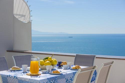 a table with food and fruit and orange juice at Estate4home - Casa Darly in Positano