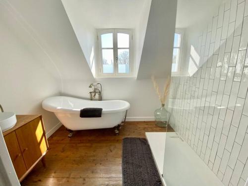 y baño blanco con lavabo y bañera. en La Villa Dorange, EXCEPTIONNELLE et SPACIEUSE, en Sailly-Flibeaucourt