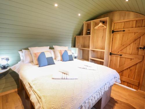 1 dormitorio con 1 cama grande y puerta de madera en Nant yr Esgair, en Machynlleth