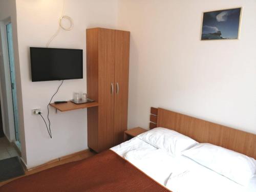 a bedroom with a bed and a tv on the wall at HOSTEL CPPI Nord in Buşteni