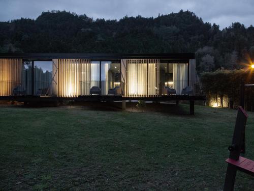 a house with a glass facade in a field at Landescape Furnas in Furnas