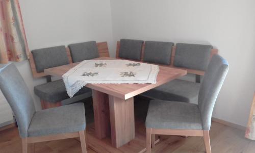 a dining room table with four chairs and a table and chairsuggest at Ferienwohnungen Fahringer Diana in Kössen