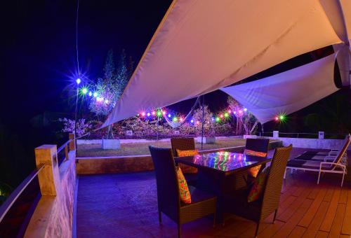 a table and chairs under a tent at night at TROPICAL HOUSE - Jungleside Villa in Hikkaduwa