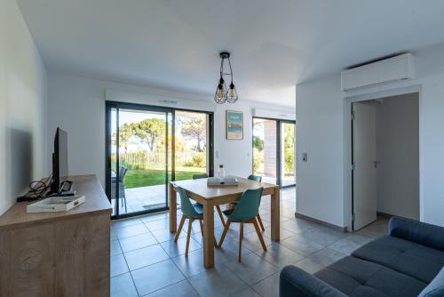 une cuisine et un salon avec une table et des chaises dans l'établissement L'eclat de Stagnola, à Pietrosella