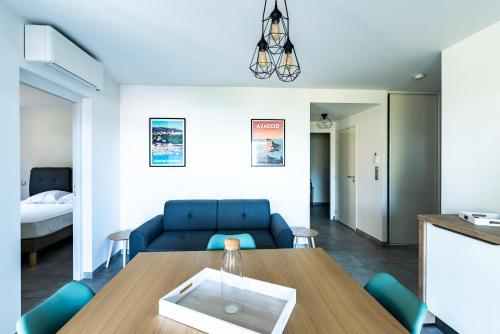a living room with a blue couch and a table at L'eclat de Stagnola in Pietrosella