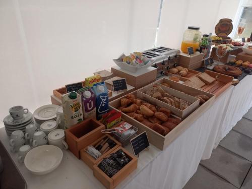 a table topped with boxes of donuts and other food at Hotel Bela Fisterra in Finisterre