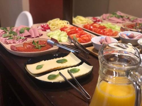 a table with plates of food and a glass of orange juice at Atrium Panzio in Esztergom