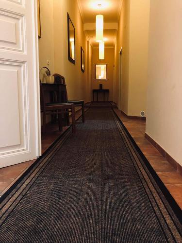 an empty hallway with a rug on the floor at Atrium Panzio in Esztergom