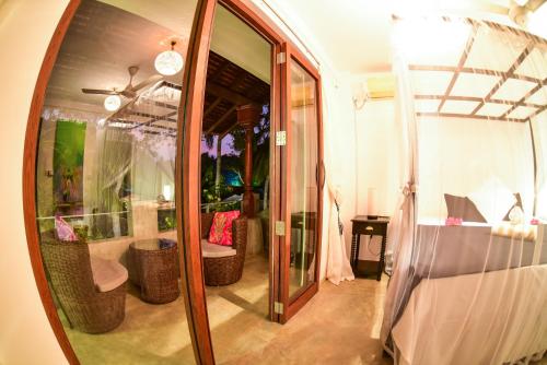 a room with a mirror and a bedroom with a bed at TROPICAL HOUSE - Jungleside Villa in Hikkaduwa