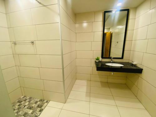 a bathroom with a sink and a mirror at Holidazzle Serviced Apartments Bahria Town in Rawalpindi