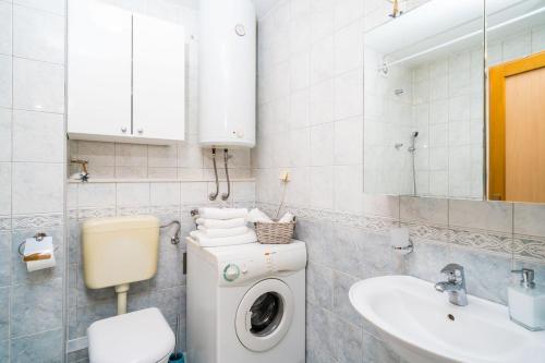 a bathroom with a washing machine and a sink at Apartment Mioć in Dubrovnik