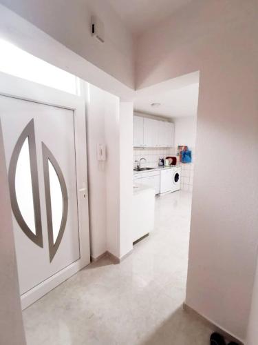a white kitchen with a large door in a room at Apartman Square in Mostar