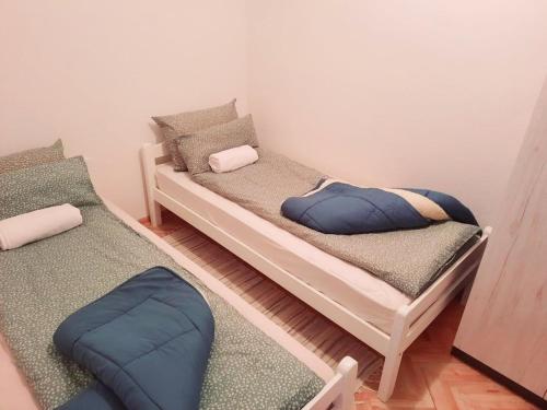 two beds in a room with two pillows at Apartman Square in Mostar