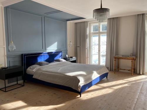 sypialnia z dużym łóżkiem z niebieskim zagłówkiem w obiekcie Dom Pułkownika w Kłodzku
