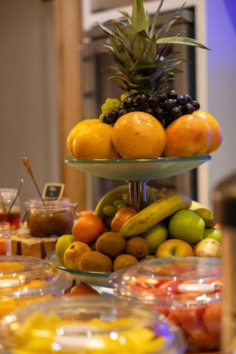 a display of fruit on a tiered plate at Hôtel et Spa La Villa K - Basel Airport in Saint-Louis
