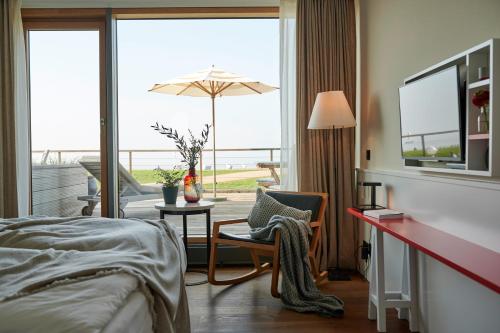 a hotel room with a bed and a balcony at Hotel Haus am Meer in Norderney