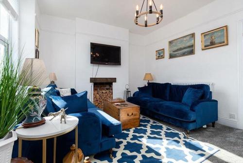 a living room with two blue couches and a tv at Haulfryn Apartment in Conwy