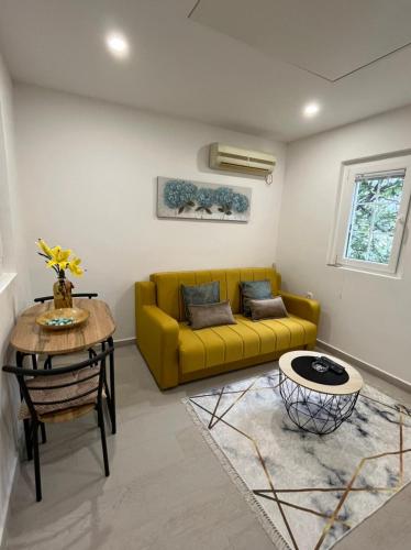 a living room with a yellow couch and a table at Dolce Casa in Kotor