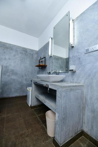 a bathroom with a sink and a mirror at TROPICAL HOUSE - Jungleside Villa in Hikkaduwa